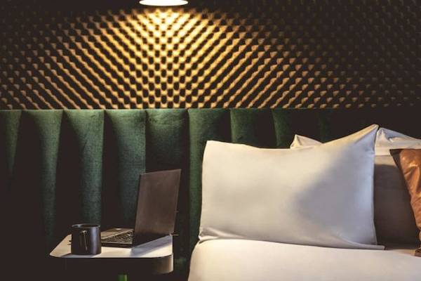 Ein Bett mit Laptop auf einem Tisch im ReMIX Hotel.