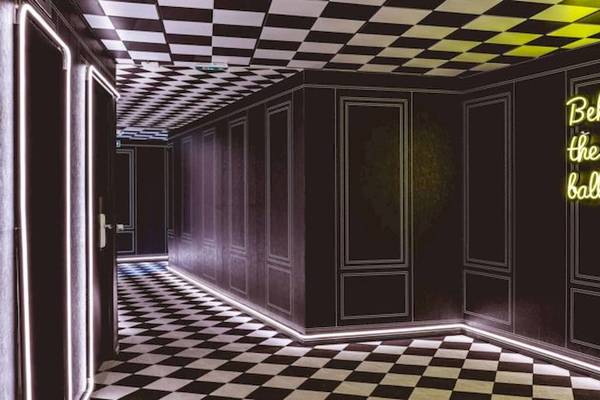 Innenansicht eines Raumes im ReMIX Hotel mit schwarzem und weißem Schachbrettboden und Wänden.