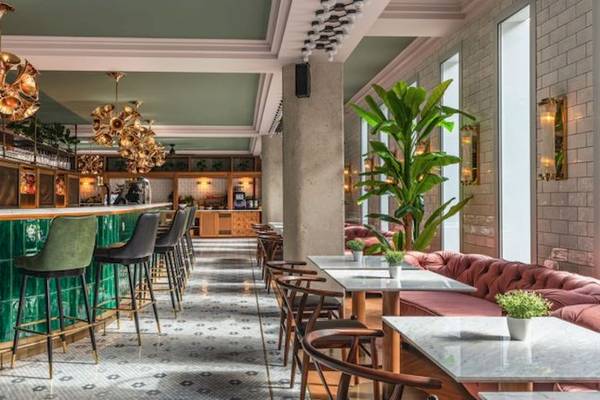 Innenbereich des ReMIX Hotels mit grüner Theke, grünen Stühlen und braunen Hockern.