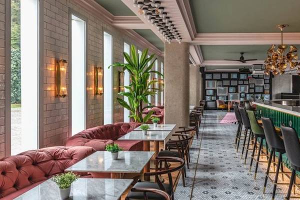 Das Innere des ReMIX Hotels mit grünen Theken, roten Sofas und hängenden Kronleuchtern.