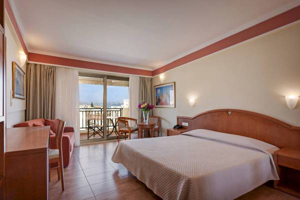 Hotelzimmer im Hydramis Palace Beach Resort mit Blick auf den Balkon und das Meer.