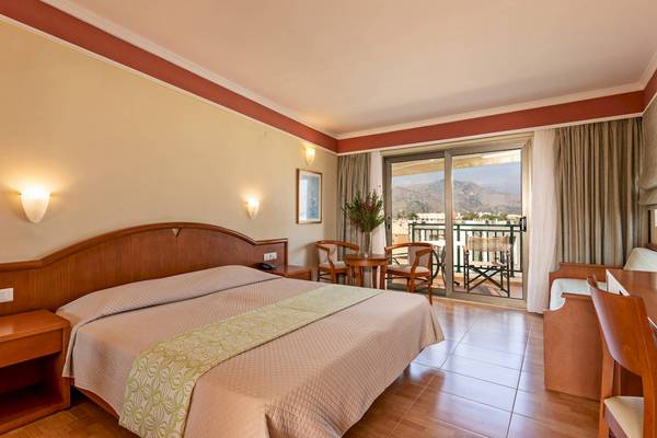 Hotelzimmer mit Doppelbett, Tisch, Stühlen und Balkon