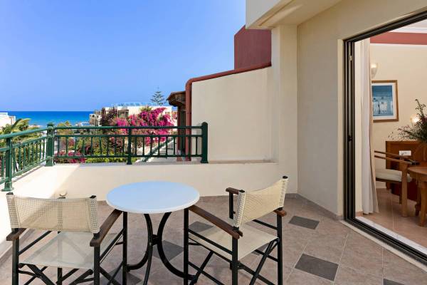 Balkon mit Meerblick im Hydramis Palace Beach Resort mit Tisch und Stühlen.