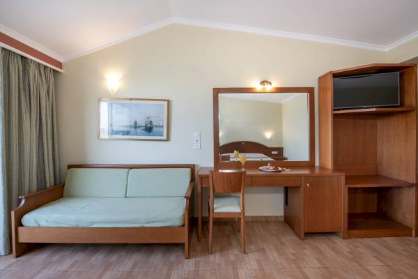 Ein Zimmer im Hydramis Palace Beach Resort mit einem Bett, einem Schreibtisch und einem Sofa.