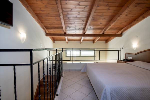 Schlafzimmer im Hydramis Palace Beach Resort mit Bett, Nachttisch und Balkon.