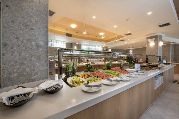 Buffet-Tisch im Hydramis Palace Beach Resort mit verschiedenen Früchten und Desserts.