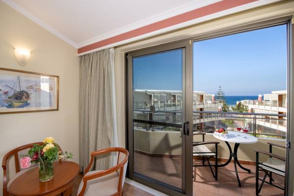 Balkon des Hydramis Palace Beach Resorts mit Blick auf das Meer und eine Stadtlandschaft.