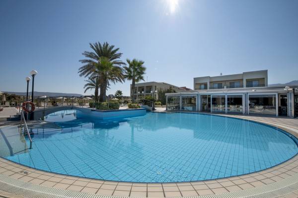 Außenpoolbereich des Hydramis Palace Beach Resorts mit Sonnenliegen und Palmen