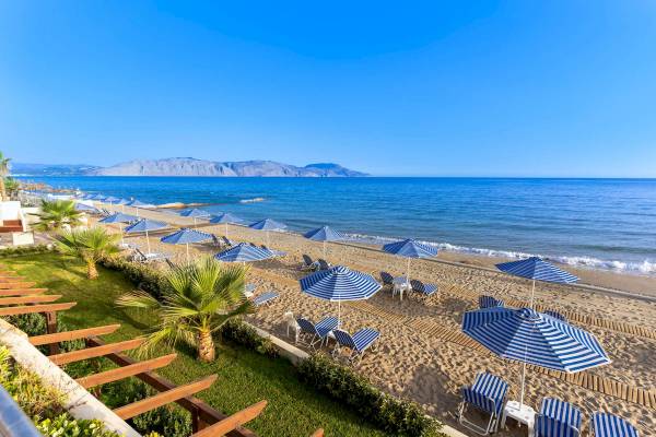 Aussicht auf den Strand des Hydramis Palace Beach Resort mit Sonnenschirmen und Liegestühlen.