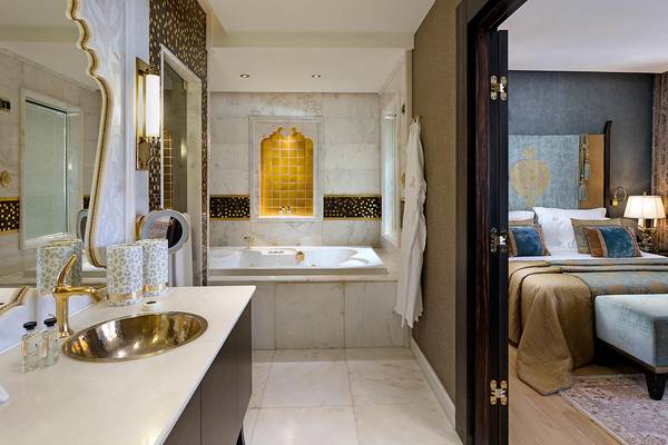 Ein Hotelzimmer mit einem Badezimmer, das eine Badewanne und einen Spiegel zeigt.