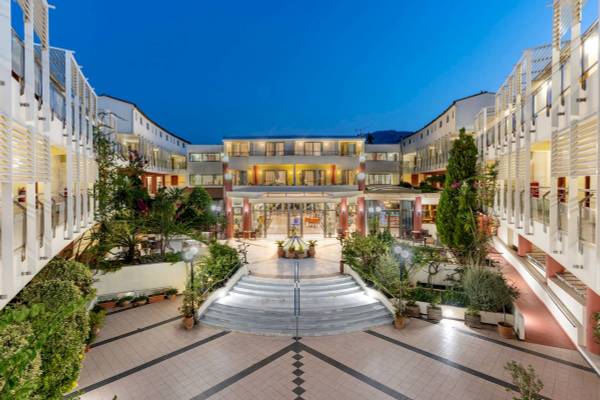 Abendansicht des Hydramis Palace Strand Resorts mit illuminierten Gebäuden und Gehweg