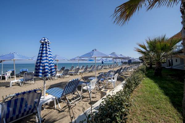 Strand des Hydramis Palace Beach Resorts mit vielen Liegen und Sonnenschirmen