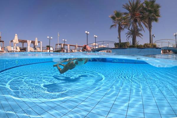 Frau schwimmt im Pool im Hydramis Palace Beach Resort