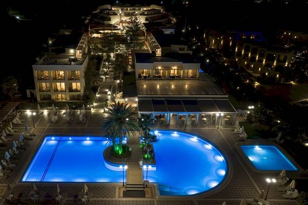 Luftaufnahme des Hydramis Palace Beach Resorts bei Nacht mit beleuchteten Gebäuden und Swimmingpools.