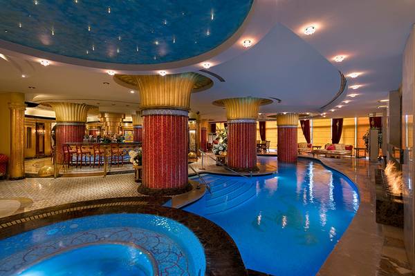 Innenpool im Titanic Mardan Palace Hotel mit ägyptischen Säulen und beleuchteter Decke.