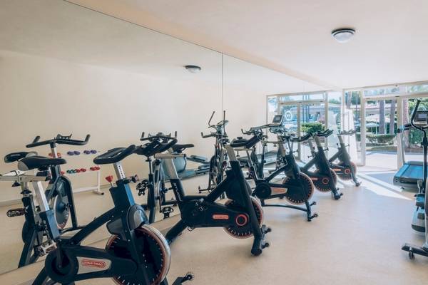 Fitnessstudio im Iberostar Waves Pinos Park Hotel mit Spinrädern und Laufbändern.