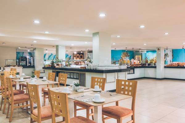 Frühstücksraum des Iberostar Waves Pinos Park Hotels mit gedeckten Tischen und Stühlen.