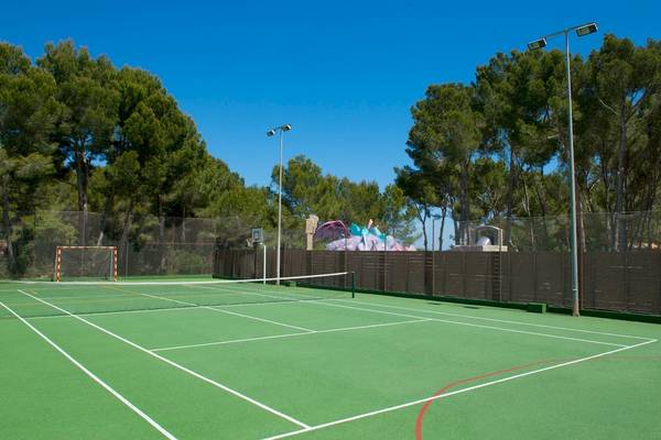 Tennisplatz im Iberostar Waves Pinos Park Hotel, umgeben von Bäumen und mit einem Basketballkorb.