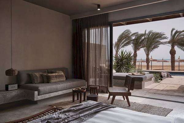 Innenansicht eines Zimmers im Casa Cook El Gouna Hotel mit Blick auf den Strand und Palmen.