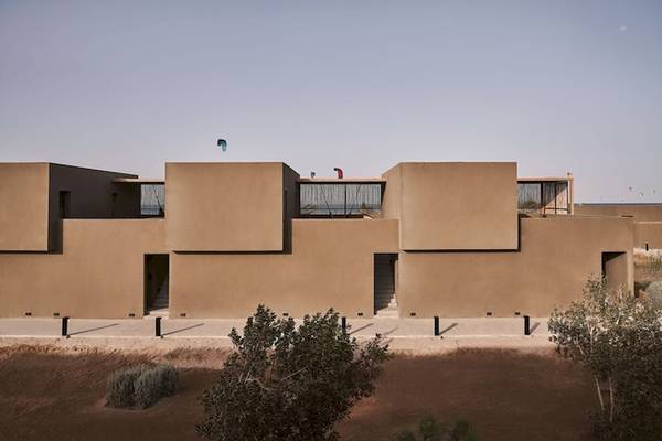 Außenansicht des Casa Cook El Gouna Hotels mit mehreren geometrischen Strukturen und einigen Personen auf der Dachterrasse.