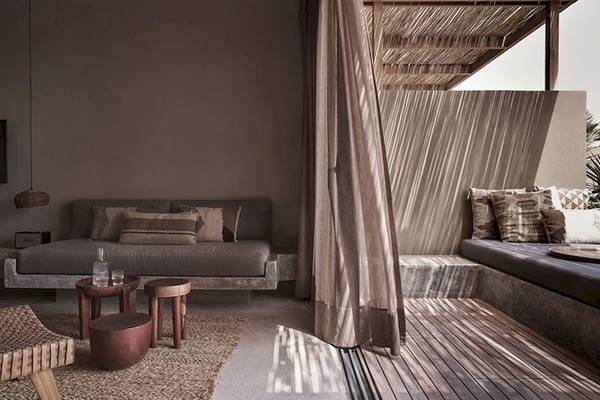Wohnbereich im Casa Cook El Gouna Hotel mit zwei Sofas, Kissen, Holztischen und Teppichen.
