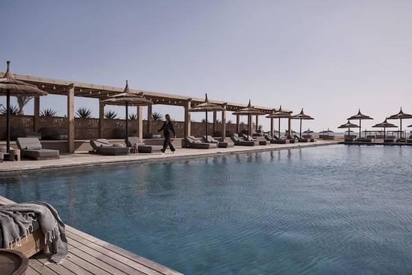Außenpoolbereich des Casa Cook El Gouna Hotels mit Lounge-Sesseln und Sonnenschirmen.