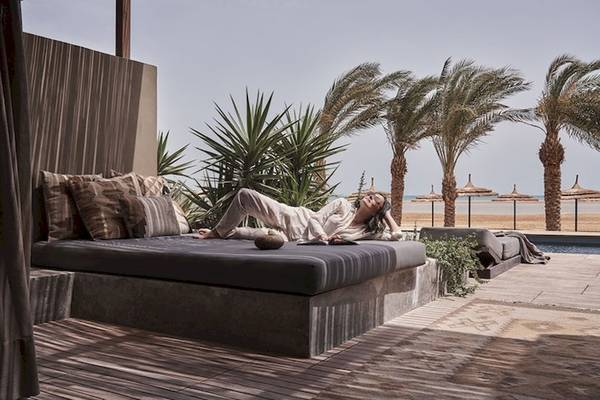 Frau liegt entspannt auf einem Bett im Freien im Casa Cook El Gouna