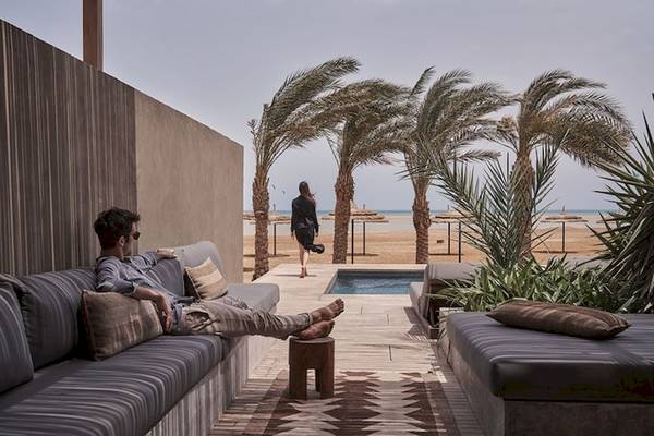 Mann auf Liege am Pool des Casa Cook El Gouna Hotels mit Blick auf den Strand