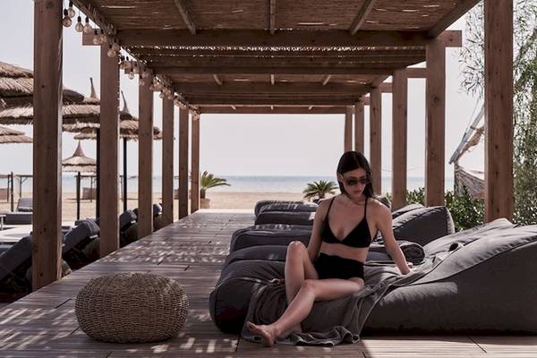 Frau in schwarzem Bikini auf Sofas am Strand des Casa Cook El Gouna