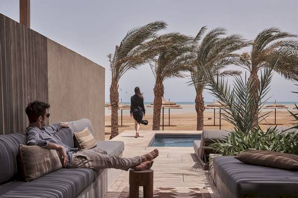 Loungebereich am Pool im Casa Cook El Gouna Hotel mit Mann und Frau im Hintergrund.