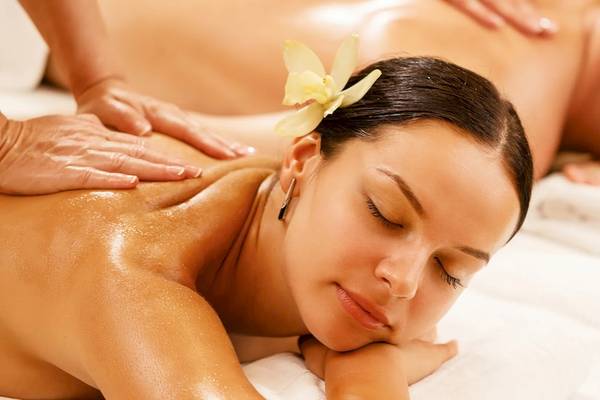 Massage im Sunrise Queen Luxury Hotel mit einer Frau, die auf einem weißen Handtuch liegt.