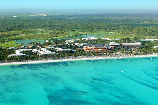 Luftaufnahme des Barcelo Bavaro Palace Hotels mit Blick auf den Strand, Gebäude und türkisfarbenes Wasser.