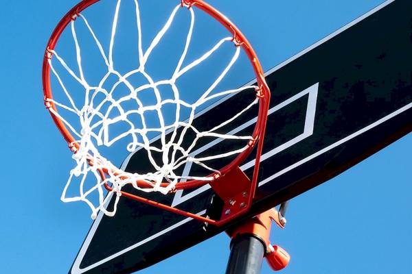 Basketballkorb mit Netz am Korbbrett, das an einem Pfosten befestigt ist.