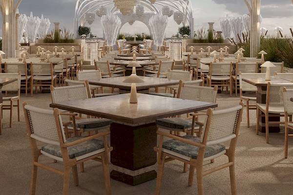 Außenbereich des Sunrise Queen Luxury Hotel mit vielen Tischen und Stühlen, umgeben von weißen Säulen und Brunnen.
