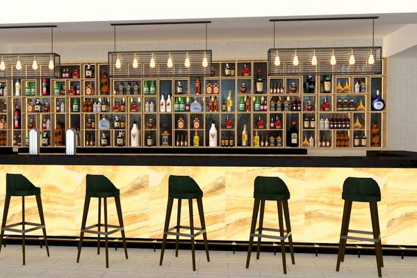 Innenansicht der Bar im Sunrise Queen Luxury Hotel mit Barhockern und einer großen Getränkewand.