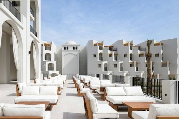 Serry Beach Resort mit weißen Lounge-Bereich im Freien, umgeben von Gebäuden.