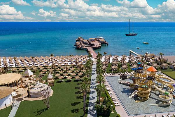 Luftaufnahme des Titanic Mardan Palace Hotels mit Meer, Pier, Wasserrutschen und Sonnenschirmen
