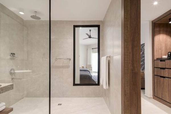 Badezimmer im Serry Beach Resort mit Regendusche, Spiegel und modernem Design.