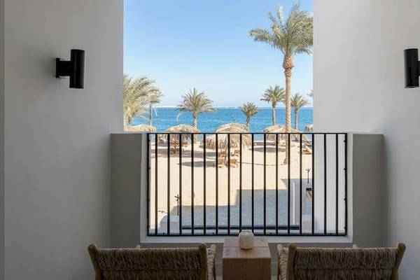 Blick aus dem Balkon des Serry Beach Resorts auf den Strand mit Palmen und Meer.