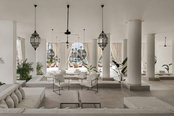 Lobby des Serry Beach Resorts mit weißen Möbeln, Säulen und Pflanzen.