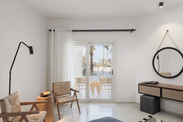 Inneneinrichtung eines Zimmers im Serry Beach Resort mit Möbeln, Lampen und Spiegeln.