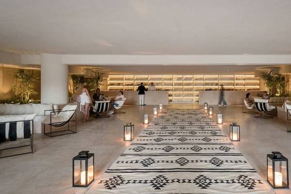 Serry Beach Resort Lobby mit gemustertem Teppich, Leuchten und Gästen.