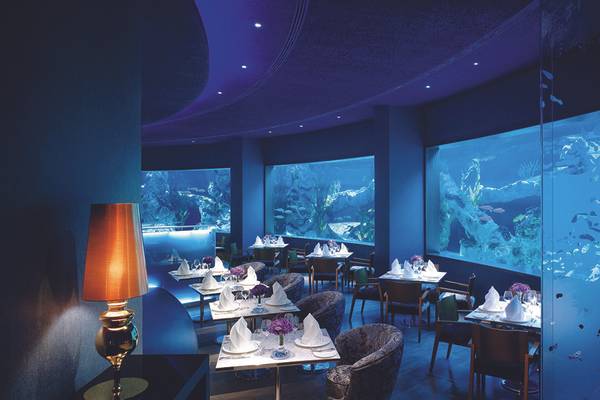 Unterwasserrestaurant des Titanic Mardan Palace mit großen Aquarien und blauer Beleuchtung.