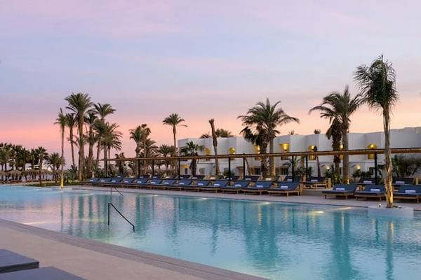 Serry Beach Resort Pool mit Lounge-Liegestühlen und Palmen bei Sonnenuntergang