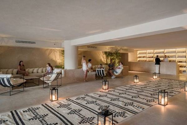 Lobby des Serry Beach Resorts mit Gästen, Möbeln und Bücherregalen.