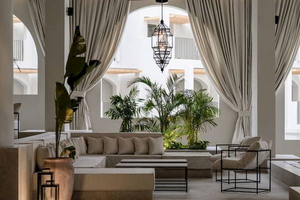 Serry Beach Resort Lobby mit weißem Möbeln, Kissen, Lampen und Pflanzen.