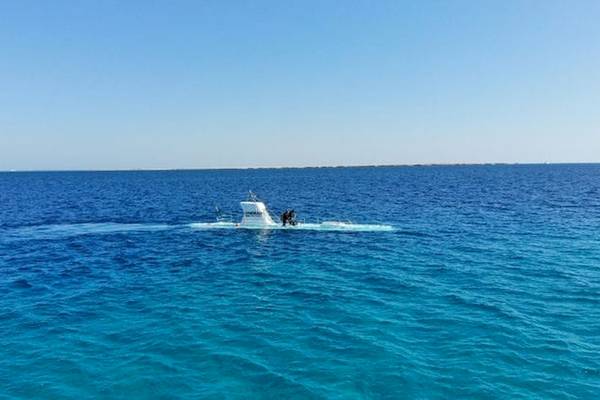 Ein Unterwasserboot im blauen Ozean mit zwei Personen an Bord.
