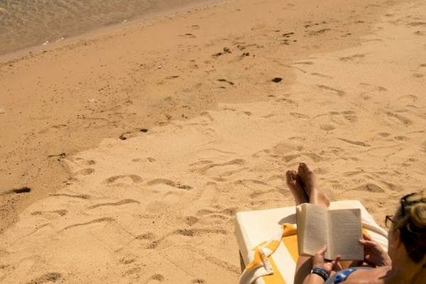 Frau liest Buch am Strand des Serry Beach Resorts