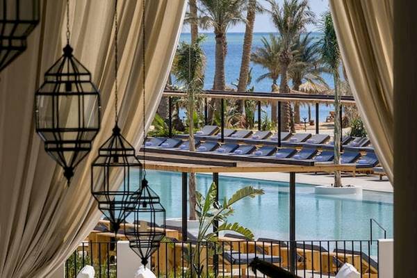 Aussicht auf den Poolbereich des Serry Beach Resorts mit Lounge-Sesseln und Meerblick.