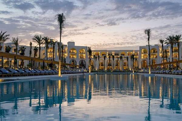 Serry Beach Resort Pool-Ansicht bei Sonnenuntergang mit Lounge-Sesseln und Palmen